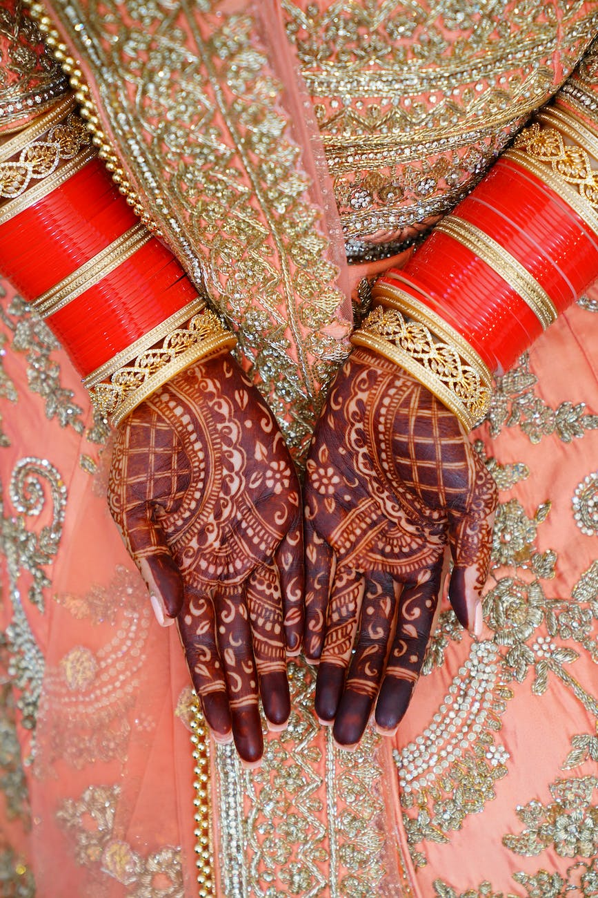crop indian bride in traditional sari with henna on hands