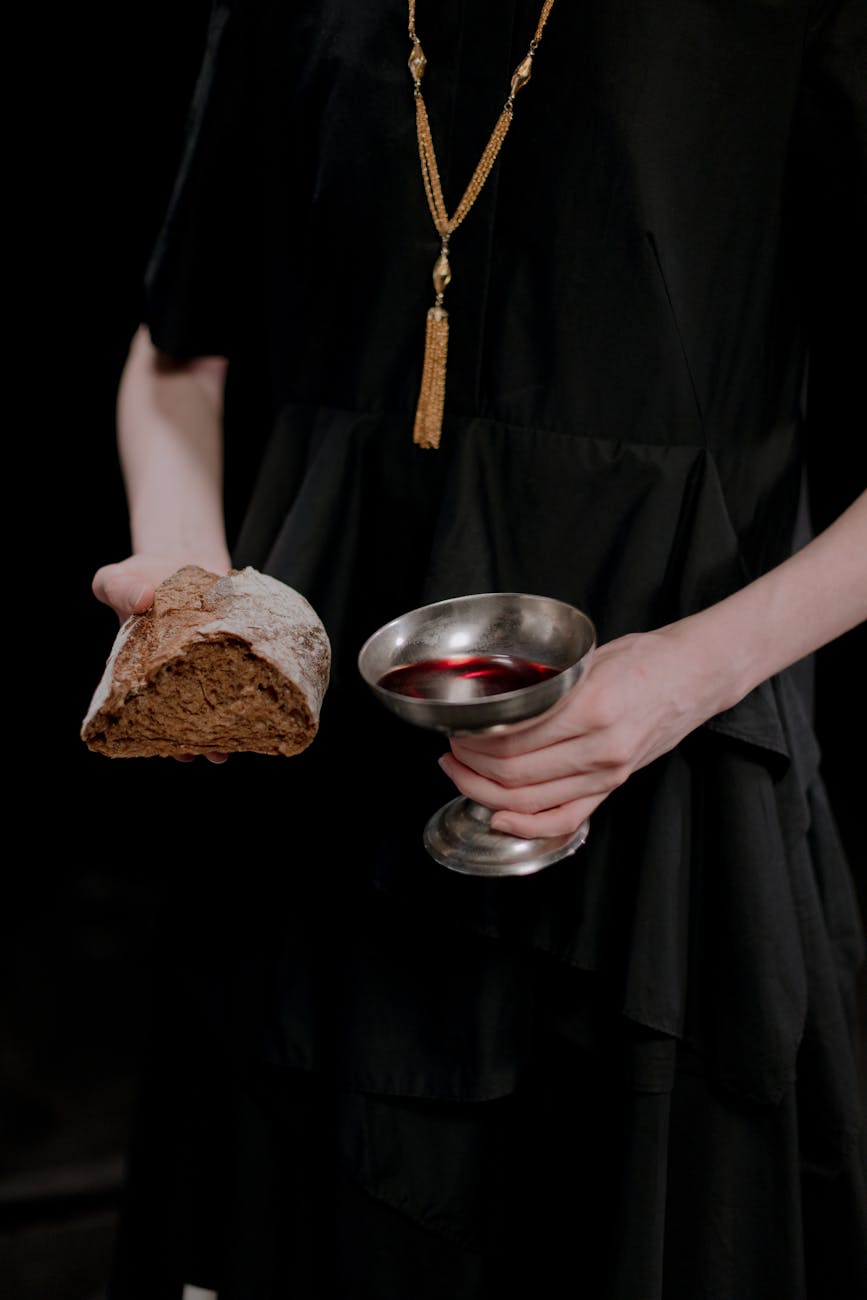 a person holding a bread and wine